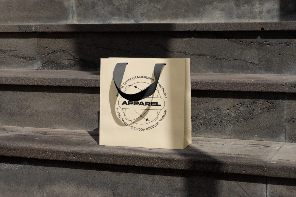 Small yellow paper bag with black handle on the concrete stairs.