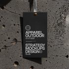 Black paper tag hanging in front of concrete wall.