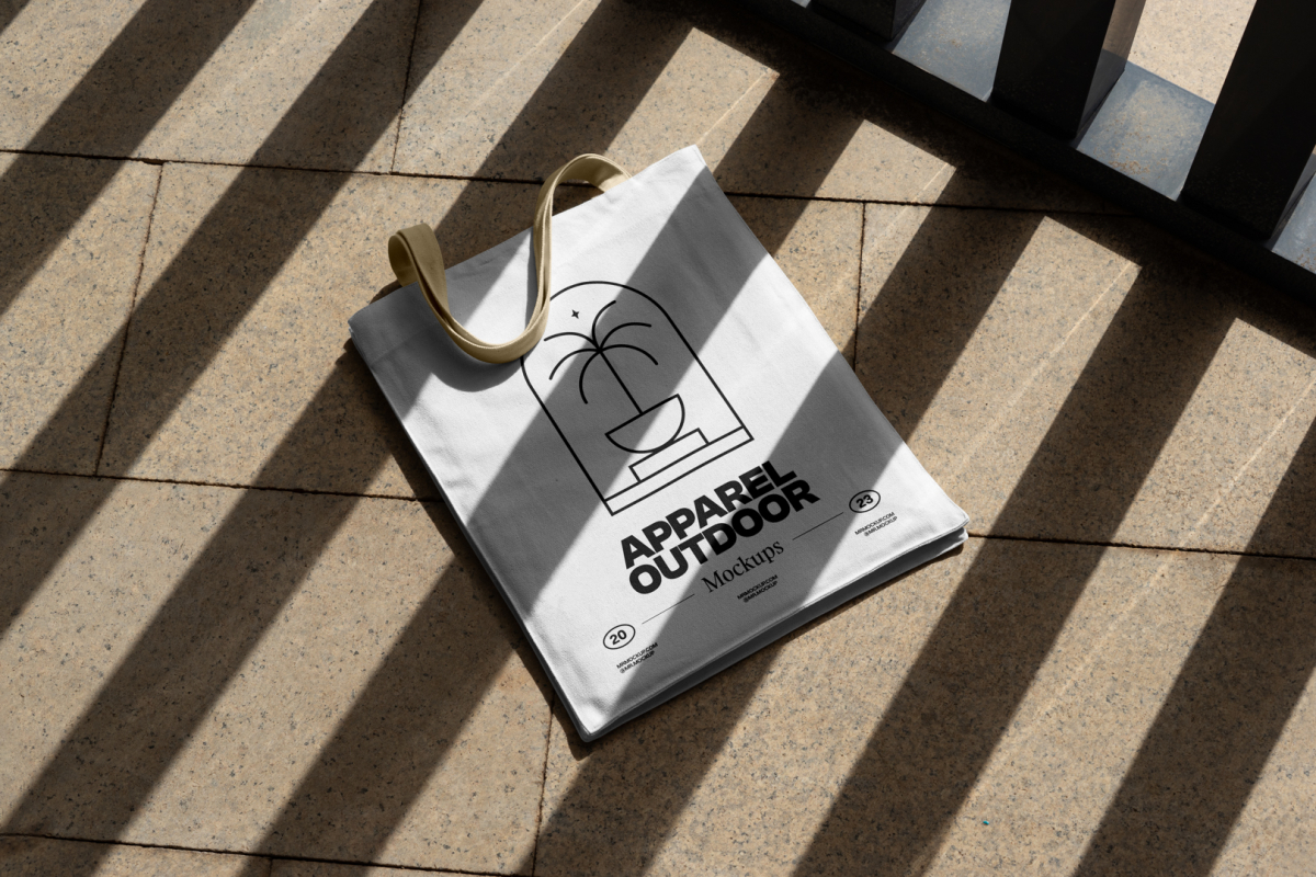 White canvas bag with beige handle laying on the granite floor.