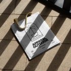 White canvas bag with beige handle laying on the granite floor.