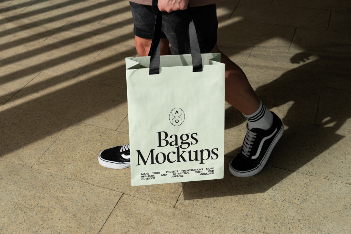 Man holding big green paper bag with typographic design.