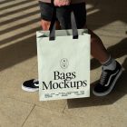 Man holding big green paper bag with typographic design.