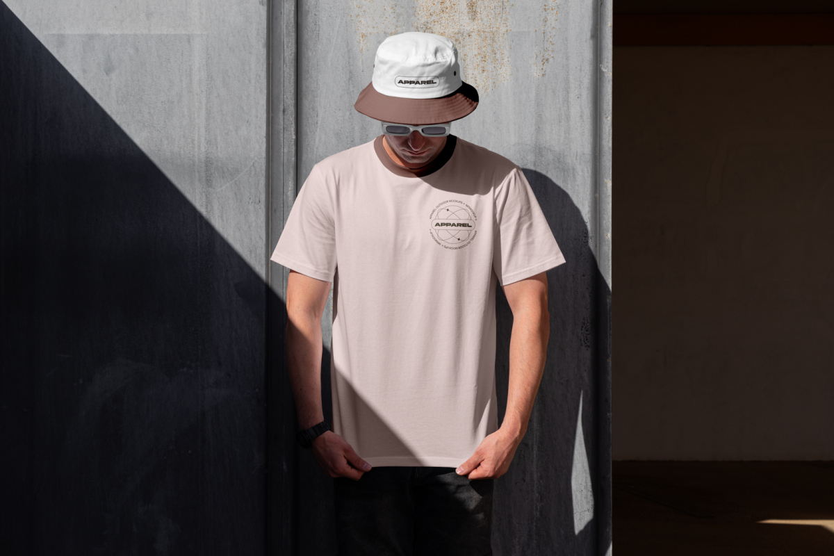 Man wearing brown t-shirt, sunglasses and bucket hat with embroidery design.