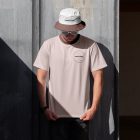 Man wearing brown t-shirt, sunglasses and bucket hat with embroidery design.