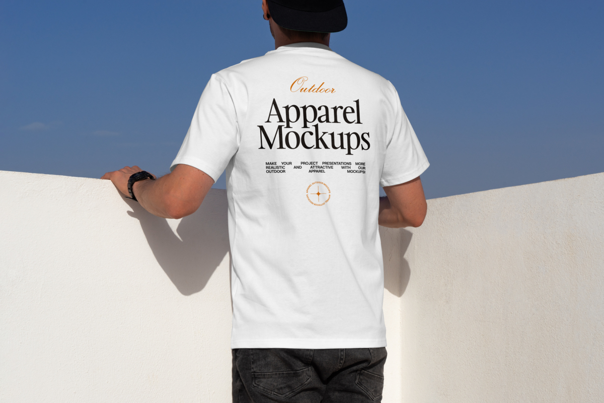 Man wearing white t-shirt in front of blue sky.