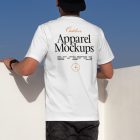 Man wearing white t-shirt in front of blue sky.
