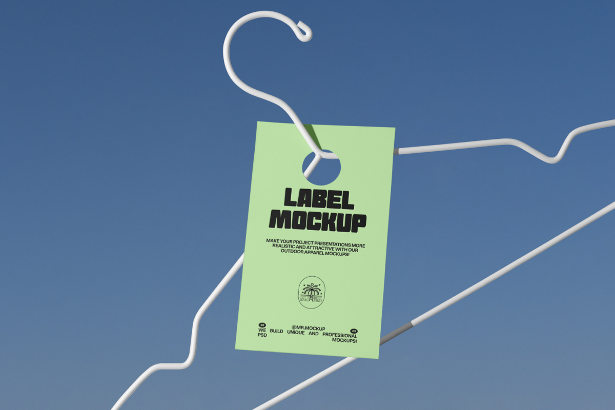 Metal hanger with green paper tag in front of blue sky.