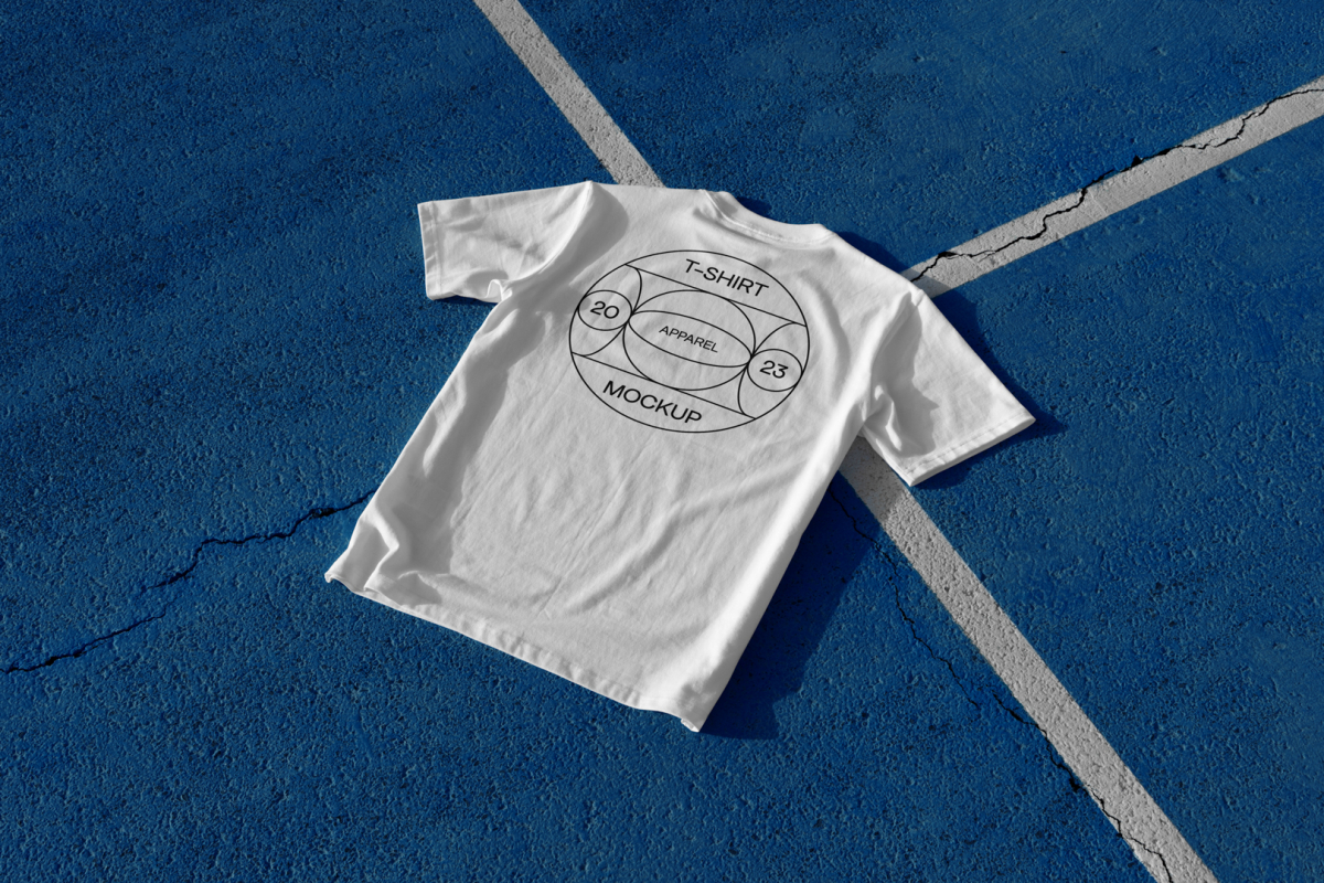 White t-shirt with big black typographic design laying on blue court.