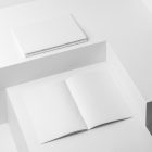 Three a4 white magazines on white cubes from studio magazine mockups.