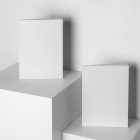 Two white magazines on white cubes from studio magazine mockups.