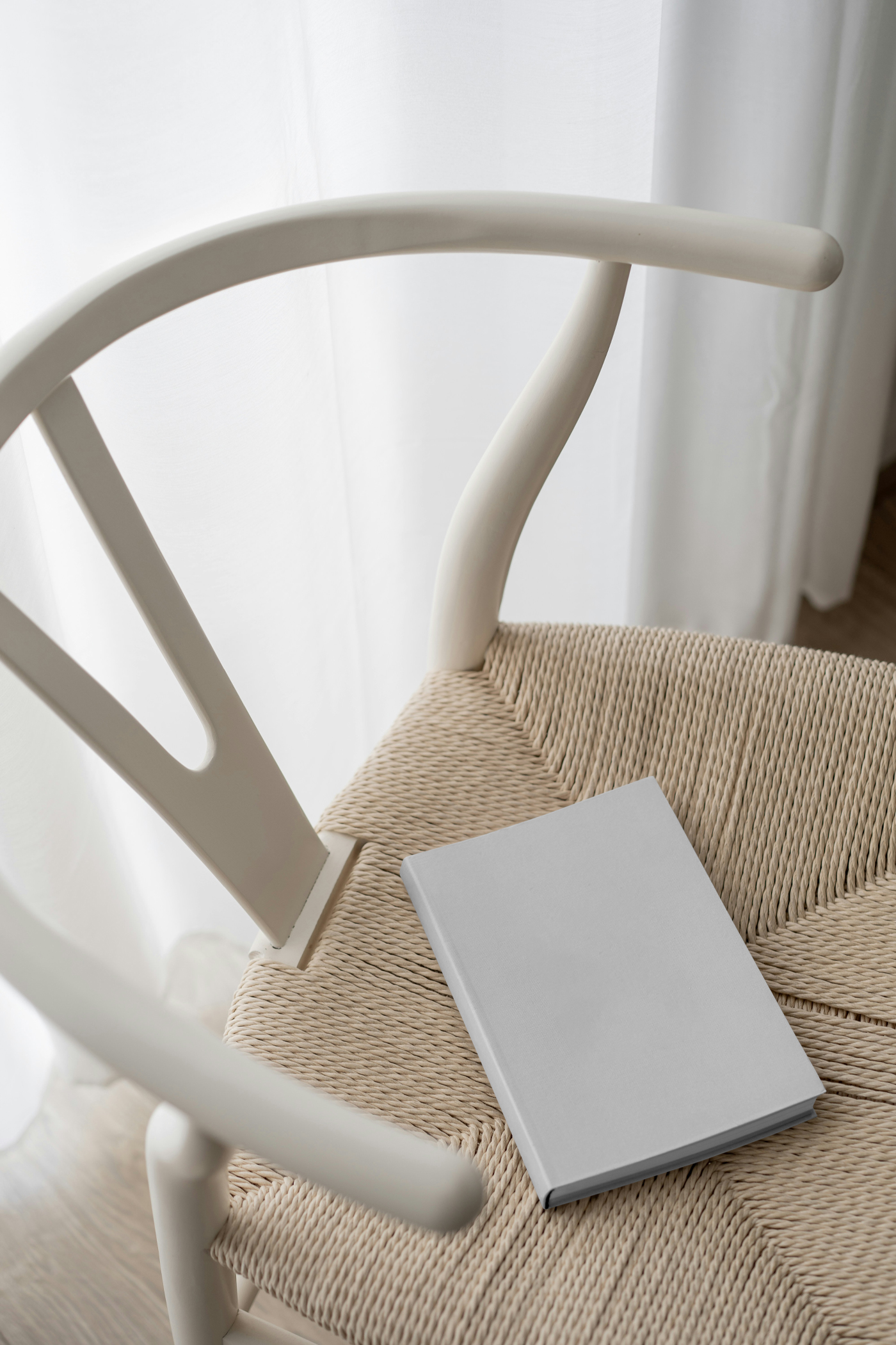 View from above, hardcover blank book mockup laying on the chair inside the flat.