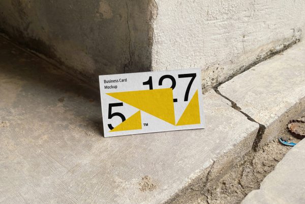 Front view, business card based on the wall corner and standing on the concrete floor.