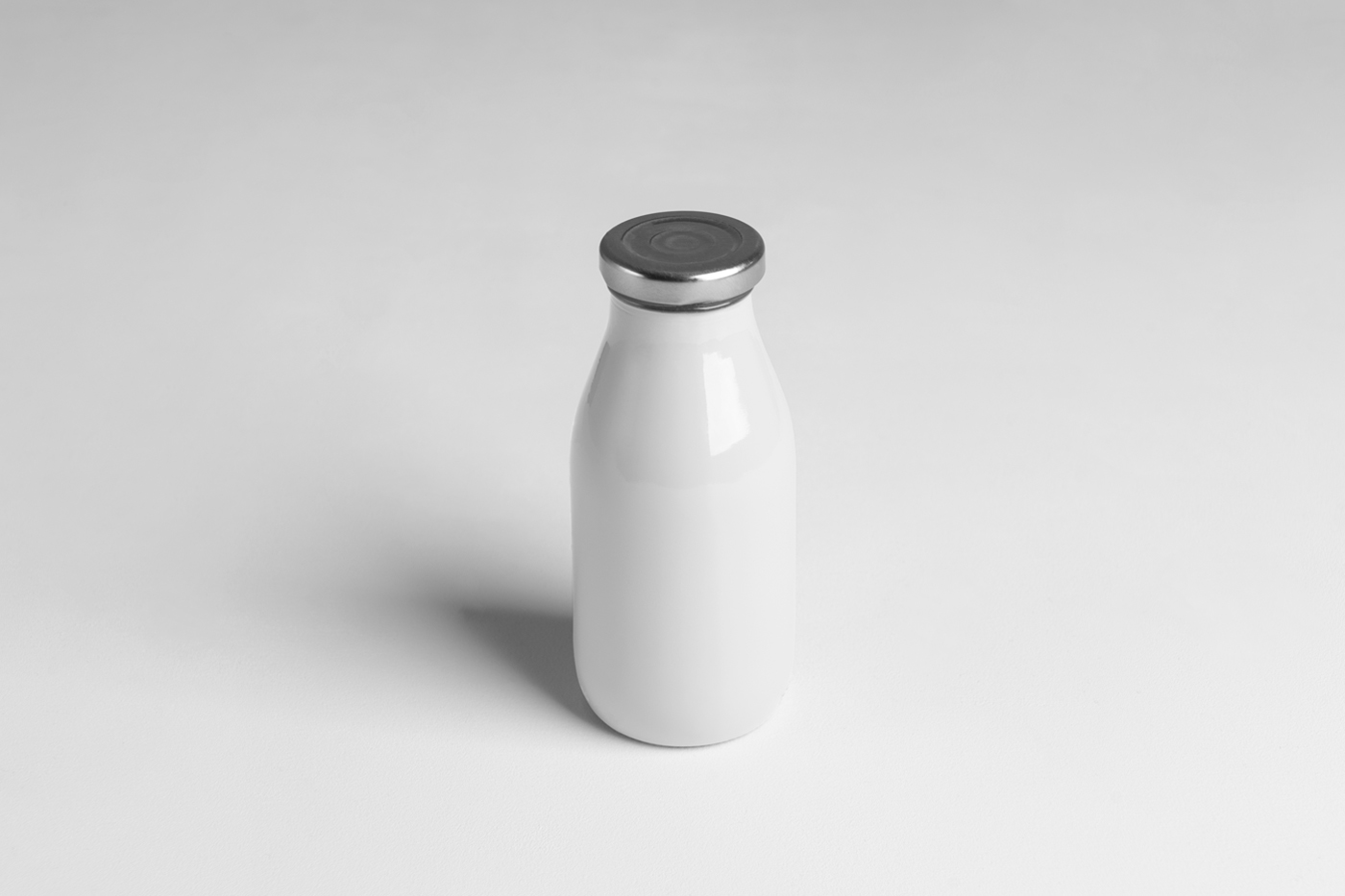 Front view, juice glass white bottle mockup standing on the white floor.
