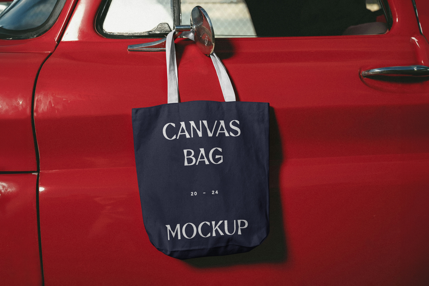 Front view, canvas bag mockup hanging on the car's red color body.