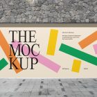 Front view, rectangle with colorful graphics and black typography space built into a stone gray wall from storefront mockups product.