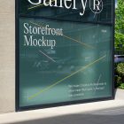 Front view, at an angle of 45 degrees, building corner with colorful graphics and white typography from storefront mockups product with windows where you can see the reflection of city life. Behind the corner are trees, cars, and another building.