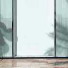Front view, transparent display window case in the building divided into three parts with black frames from storefront mockups product.