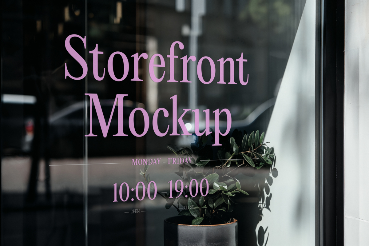 Front view, at an angle of 45 degrees, clean glass window with colorful graphics and pink strong typography from storefront mockups product.