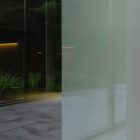 Front view, at an angle of 45 degrees, transparent glass window from storefront mockups product where you can see the reflection of estates.