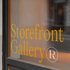 Front view, at an angle of 45 degrees, clean glass window with colorful graphics and orange stong typography from storefront mockups product.