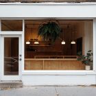 Front view, white restaurant facade with transparent windows and door from storefront mockups product.