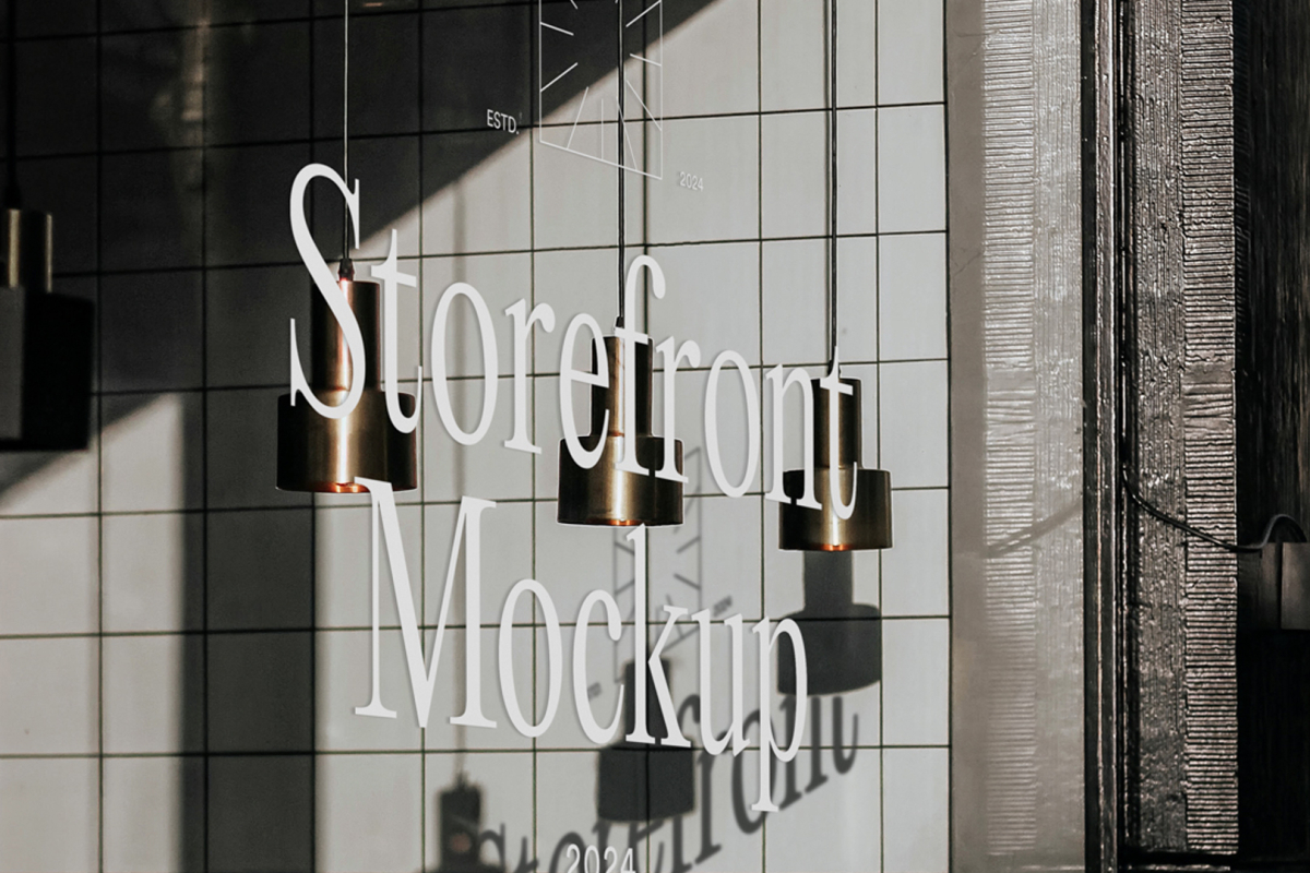 Front view, at an angle of 45 degrees, clean glass window with colorful graphics and white typography with visible shadows from storefront mockups product.
