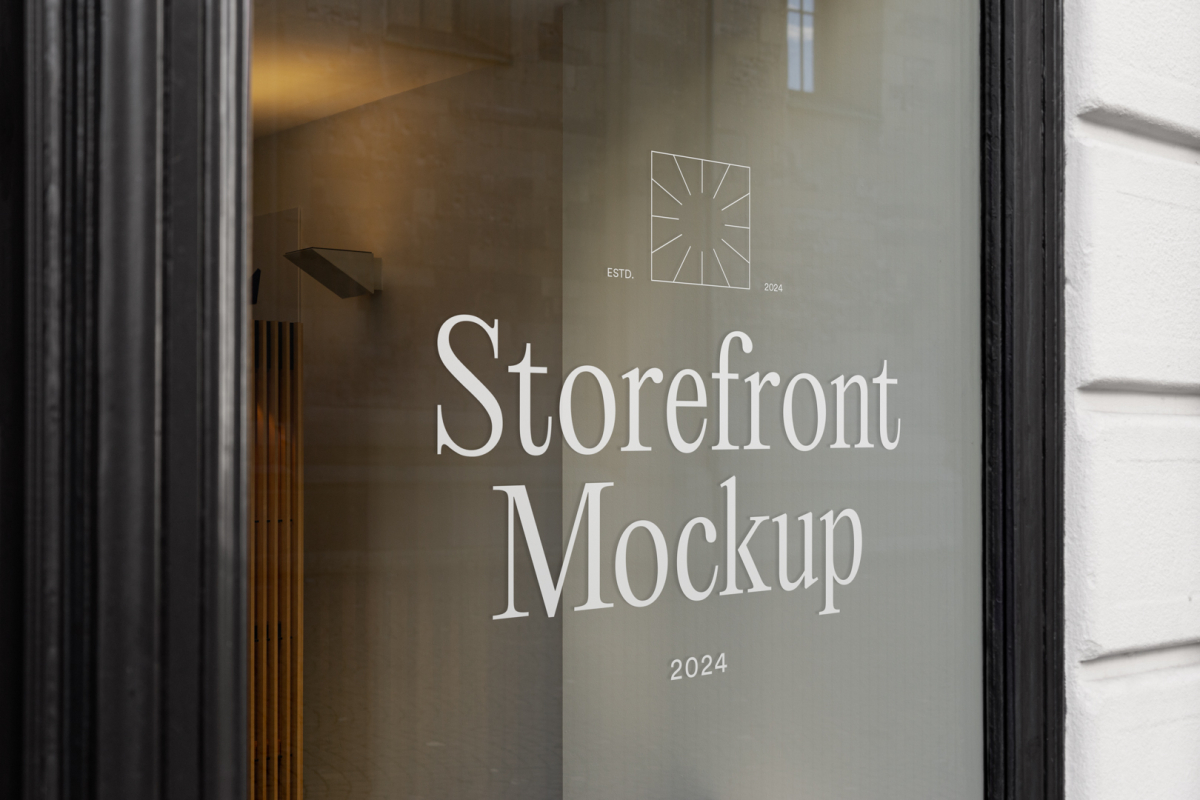 Front view, at an angle of 45 degrees, clean glass window with colorful graphics and white typography with visible shadows from storefront mockups product.