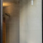 Front view, at an angle of 45 degrees, transparent glass window from storefront mockups product where you can see the reflection of estates.