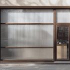 Front view, entrance to the small shop facade with brown frames, five windows and close glass door from storefront mockups product.