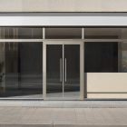 Front view, entrance to the staircase facade with dark green frames, seven windows, close glass door and one white coffer from storefront mockups product.