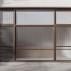 Front view, entrance to the small shop facade with brown frames, five windows and close glass door from storefront mockups product.