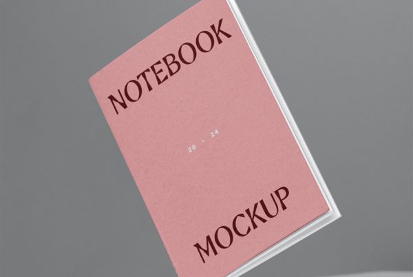 Front view, mini notebook mockup levitating above a gray color desk.