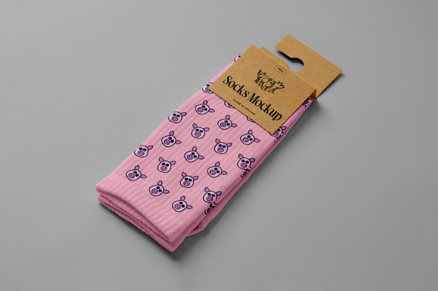 View from above, pink pair of socks mockup with a craft paper label attached to it, laying on the gray floor.