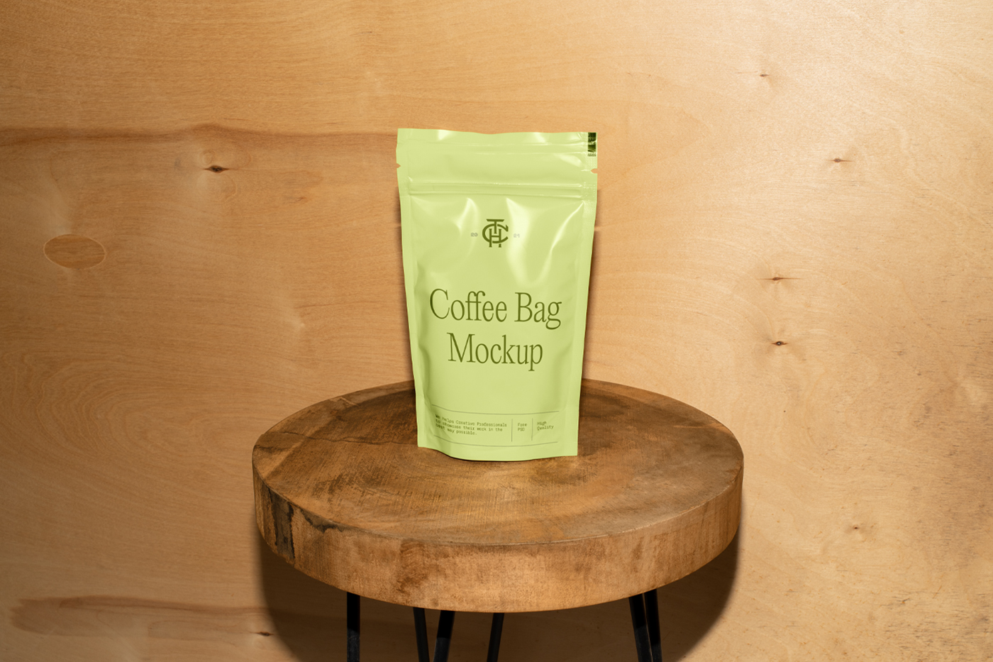 Front view, green coffee bag mockup standing on the wooden stool in front of the wooden wall.