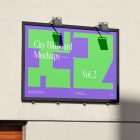 Horizontal city billboard mockup with a green, purple design and black strong frames attached to the building's beige wall elevation.