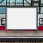 Front view, white city billboard mockup with metal gray frames standing on the platform with a subway tram in the background.