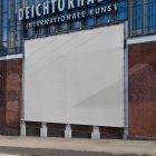 A big white horizontal city billboard mockup attached to the brick wall elevation.