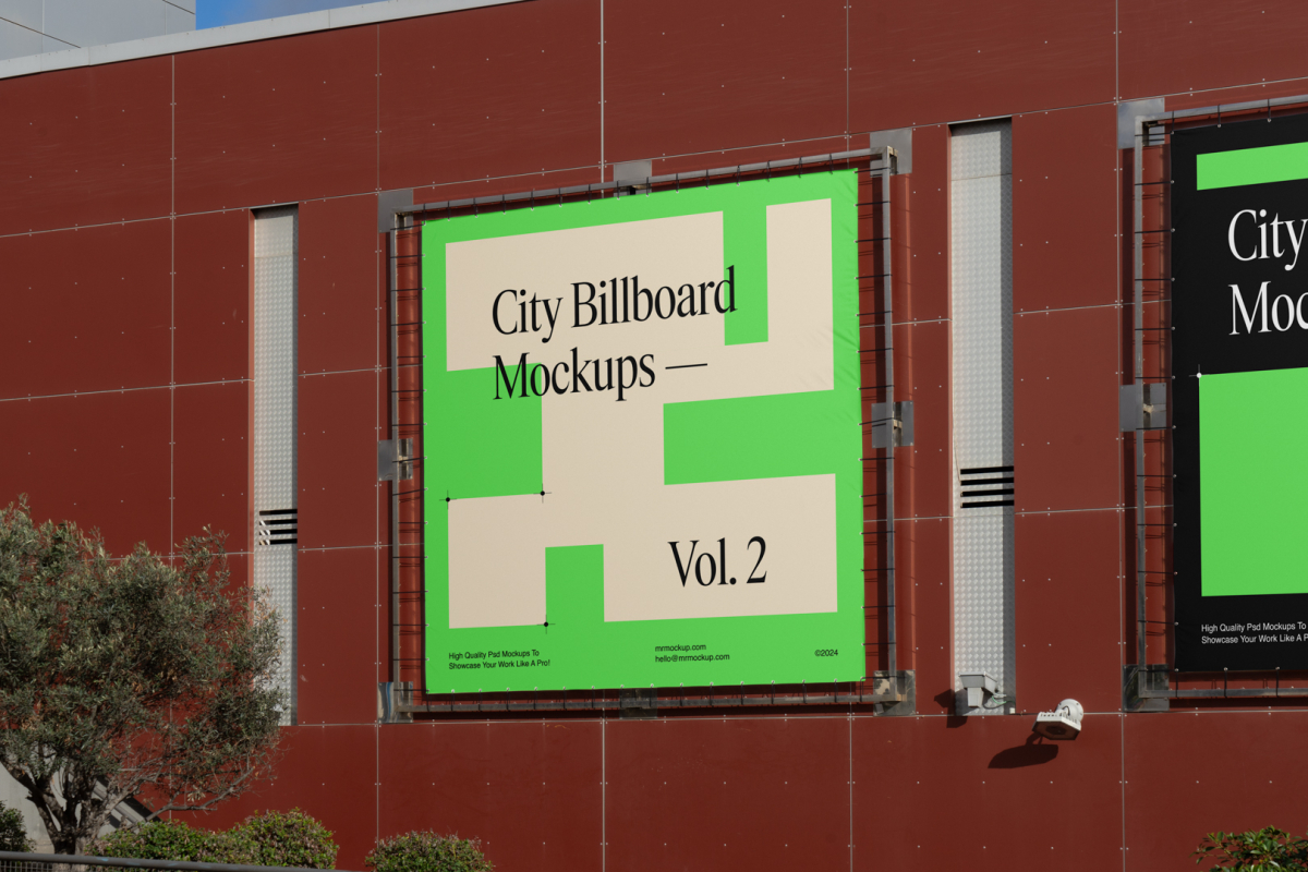 Two square city billboard mockups with a black, green design attached to the red-colored building elevation wall.