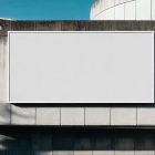 Front view, white horizontal city billboard mockup with white frames attached to the concrete building facade.