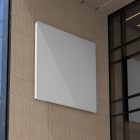 White square city billboard mockup with white frames attached to the beige building facade.
