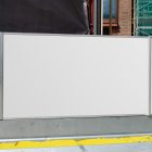 Three white horizontal city billboard mockups hung on the metal fence.