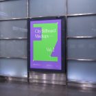 Vertical city billboard mockup with purple design right at the subway station entrance attached to the wall.