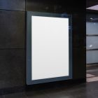 Vertical white city billboard mockup attached to the black marble wall.