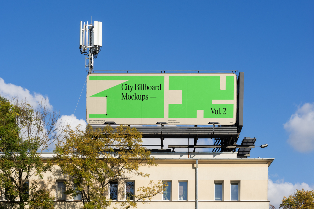 Front view, city billboard mockup attached to the roof of the building, with the clean blue sky in the background.