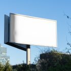 Front view, white city billboard mockup with the clean blue sky in the background.