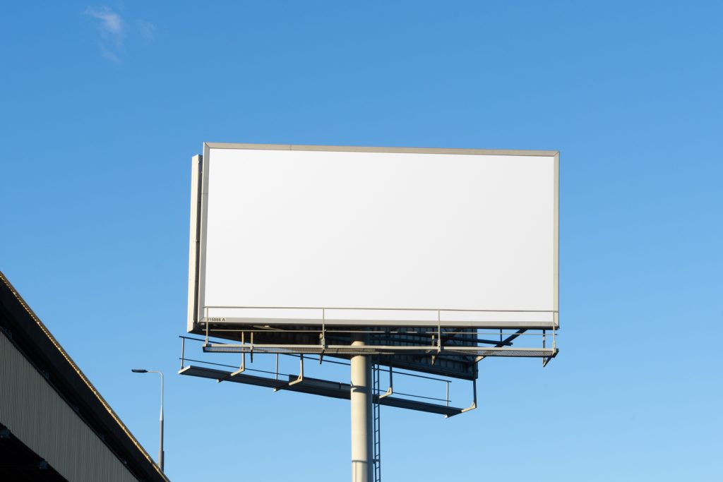 Front view, white city billboard mockup with the clean blue sky in the background.