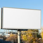 Front view, white city billboard mockup with silver frames and black, with the clean blue sky in the background.