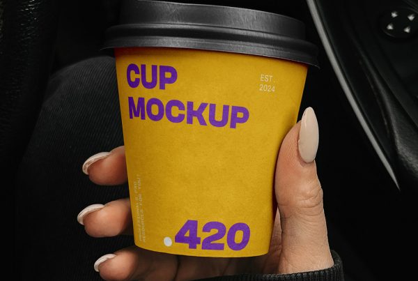 Woman holding a yellow paper coffee cup mockup inside the car.