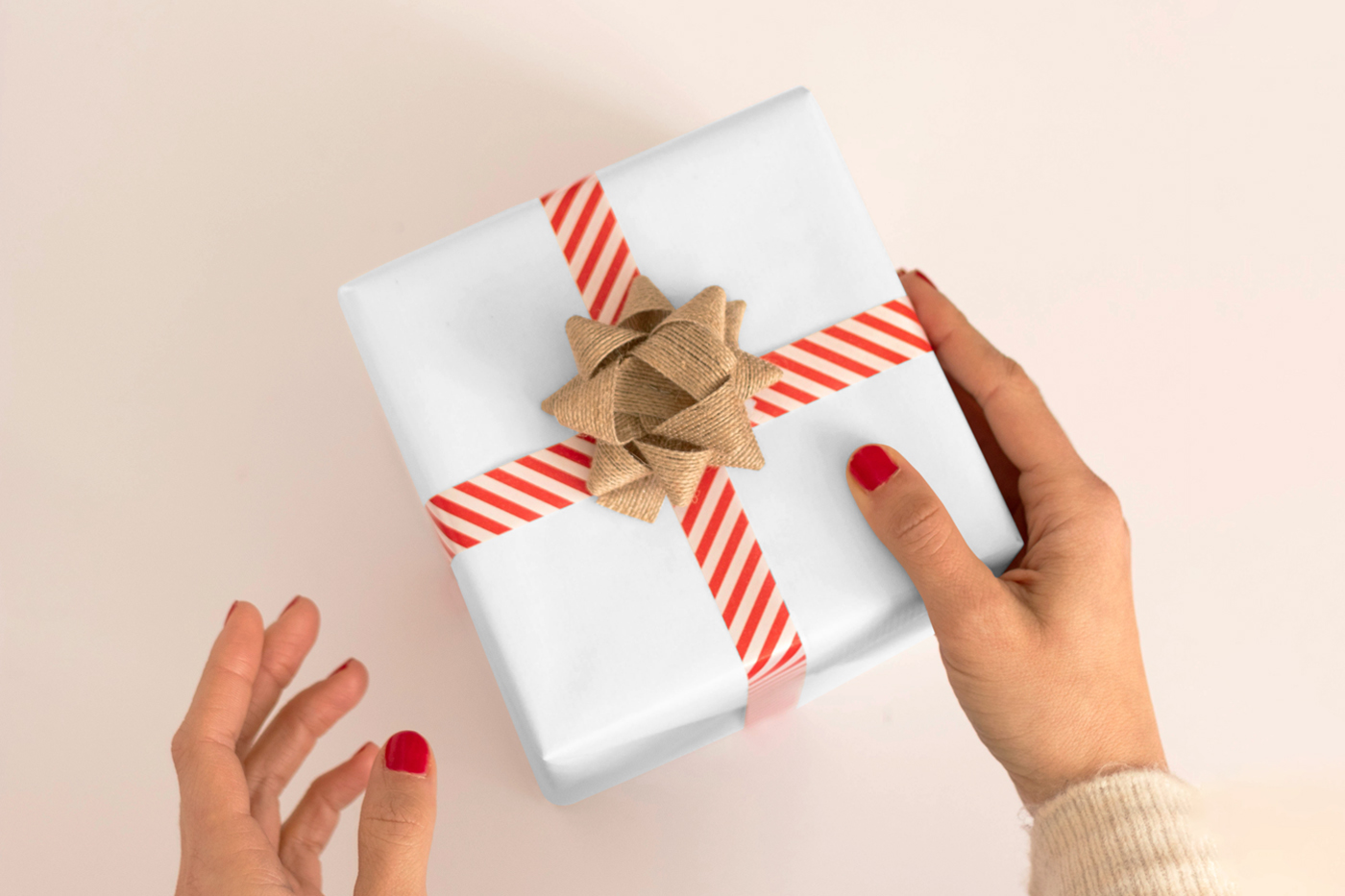 View from above, white gift box mockup laying on the bright beige floor.