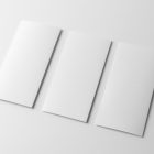 View from above, at a 45-degree angle of three white Trifold Mockups laying on a white floor.